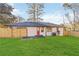 Newly fenced backyard features a well-maintained lawn and access to a back entrance with red door at 1796 Arkose Se Dr, Atlanta, GA 30316