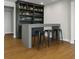 Features a stylish bar area with custom shelving, storage for bottles and glassware, and comfortable stools at 6355 Westfallen Overlook, Cumming, GA 30040