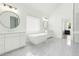 Bright bathroom featuring double vanity, soaking tub, modern fixtures, and tile flooring at 6355 Westfallen Overlook, Cumming, GA 30040
