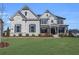 Striking two-story home featuring a combination of painted brick and stone with a well-manicured lawn at 6355 Westfallen Overlook, Cumming, GA 30040