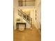 Bright foyer featuring hardwood floors, a staircase, and a decorative table with mirror and decor at 6355 Westfallen Overlook, Cumming, GA 30040