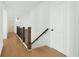 Upstairs hallway with hardwood floors, white walls, wood railing and contrasting black metal spindles at 6355 Westfallen Overlook, Cumming, GA 30040