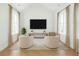 Bright living room with two chairs, large windows, and a television at 6355 Westfallen Overlook, Cumming, GA 30040
