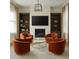 Cozy living room with fireplace, four chairs, modern light fixture, and built-in shelving at 6355 Westfallen Overlook, Cumming, GA 30040