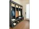 Mudroom with dark gray built-in storage, bench, hooks, and shoe storage at 6355 Westfallen Overlook, Cumming, GA 30040