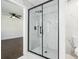 A luxurious marble tiled shower with black hardware and a view into a bedroom at 7540 Conyers St, Lithonia, GA 30058