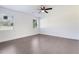 Bright bedroom featuring hardwood floors, two windows, and fan at 7540 Conyers St, Lithonia, GA 30058