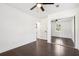 Spacious bedroom featuring mirrored closet, dark hardwood flooring, and ceiling fan at 7540 Conyers St, Lithonia, GA 30058