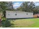 A view of the side of a house with green grass and big trees around it at 7540 Conyers St, Lithonia, GA 30058