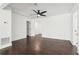 Bright living room features dark wood floors, white walls, and ceiling fan at 7540 Conyers St, Lithonia, GA 30058