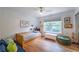 Bright bedroom boasts hardwood floors, a ceiling fan, and a window with a view of lush greenery, creating a serene atmosphere at 82 Dearborn Se St, Atlanta, GA 30317