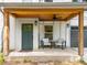 Inviting front porch with a wood ceiling, modern lighting, and a seating area at 82 Dearborn Se St, Atlanta, GA 30317