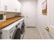 Functional laundry room featuring white cabinetry, butcher block countertop, updated appliances, and a decorative tile floor at 82 Dearborn Se St, Atlanta, GA 30317