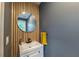Stylish powder room with a round mirror, wood accent wall, and modern fixtures at 82 Dearborn Se St, Atlanta, GA 30317