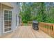 Wooden deck with grill, exterior view of the home, and view of the wooded backyard at 102 Woodsfield Ln, Hiram, GA 30141
