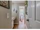 Hallway leading to a well-lit bathroom featuring modern fixtures, and wood-look floors at 102 Woodsfield Ln, Hiram, GA 30141