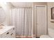 Bathroom with a white vanity, patterned shower curtain, and updated lighting at 102 Woodsfield Ln, Hiram, GA 30141