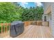 Spacious wooden deck with a grill and railing overlooking the lush backyard at 102 Woodsfield Ln, Hiram, GA 30141