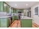 Stylish kitchen features green cabinets, stainless steel appliances, island and hardwood floors at 102 Woodsfield Ln, Hiram, GA 30141