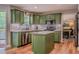 Updated kitchen boasts green cabinets, stainless appliances, and a center island with quartz countertops at 102 Woodsfield Ln, Hiram, GA 30141
