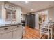 Modern kitchenette with white cabinets, stainless steel sink, and view to bedroom and dining area at 102 Woodsfield Ln, Hiram, GA 30141