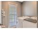 Functional laundry area with modern appliances, ample space, and a window for natural light at 102 Woodsfield Ln, Hiram, GA 30141