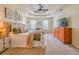 Bright main bedroom featuring a tray ceiling, ceiling fan, neutral carpet, and comfortable bedding at 102 Woodsfield Ln, Hiram, GA 30141