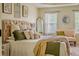 Well-lit main bedroom with bed, throw pillows, large windows, and a decorative mirror at 102 Woodsfield Ln, Hiram, GA 30141