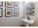 Chic powder room featuring a stylish pedestal sink, modern faucet, and unique wall art at 102 Woodsfield Ln, Hiram, GA 30141