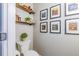 Stylish powder room with a modern toilet, floating shelves, and unique Van Gogh art decor at 102 Woodsfield Ln, Hiram, GA 30141