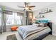 Cozy bedroom with modern decor, including a ceiling fan, decorative pillows, and natural light from a large window at 1700 Prospect Way, Conyers, GA 30094