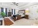 Bright bedroom features tray ceilings, a ceiling fan, and an upholstered headboard on the bed at 1700 Prospect Way, Conyers, GA 30094
