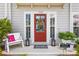 Welcoming front entrance with a red door, sidelights, bench, and decorative lanterns and planters at 1700 Prospect Way, Conyers, GA 30094