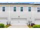 A neat two-car garage door surrounded by neutral siding with three windows above at 1700 Prospect Way, Conyers, GA 30094