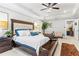 Bright main bedroom featuring a luxurious bed, tray ceilings, and ensuite bathroom at 1700 Prospect Way, Conyers, GA 30094