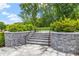 Picturesque stone walking path with steps leading to a bench, surrounded by lush landscaping and mature trees at 1700 Prospect Way, Conyers, GA 30094