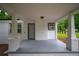 Spacious covered porch with painted brick pillars, gray painted floor, and a view of the front yard at 2137 Delowe Dr, Atlanta, GA 30344