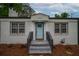 Charming single-story home featuring a light blue front door and brick accents, with landscaped front yard at 2137 Delowe Dr, Atlanta, GA 30344