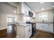 Stylish kitchen featuring stainless steel appliances, white cabinets, and dark wood flooring at 2137 Delowe Dr, Atlanta, GA 30344