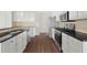 Well-lit kitchen features stainless steel appliances, granite countertops, white cabinets, and hardwood floors at 221 Cutbank Sw Ct, Atlanta, GA 30331
