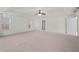 Spacious main bedroom featuring neutral carpet, tray ceiling with ceiling fan, and natural light from the windows at 221 Cutbank Sw Ct, Atlanta, GA 30331