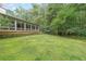 Lush backyard with an enclosed porch and mature trees offering serenity and shade at 3601 Club Nw Dr, Kennesaw, GA 30144