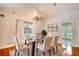 Cozy dining room featuring hardwood floors, modern lighting, a glass table, and bright, neutral walls at 3601 Club Nw Dr, Kennesaw, GA 30144