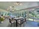 Bright sunroom with multiple windows and ceiling fans overlooking the backyard and surrounded by nature at 3601 Club Nw Dr, Kennesaw, GA 30144