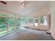 Enclosed sunroom featuring lots of light, lush landscaping, and access to an outdoor deck at 3601 Club Nw Dr, Kennesaw, GA 30144