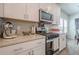 Well-equipped kitchen with stainless steel microwave, oven, and gas range, complemented by white cabinets at 422 Murphy Avenue, Canton, GA 30114