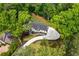An aerial view of a modern home with beautiful landscaping, a long driveway, and mature trees at 1155 Peachtree Battle Nw Ave, Atlanta, GA 30327