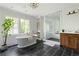 Bright bathroom boasts a soaking tub, glass-enclosed shower, and wooden vanity with double sinks at 1155 Peachtree Battle Nw Ave, Atlanta, GA 30327