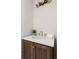 Elegant half bathroom featuring dark wood vanity, gold hardware, white countertop and faucet with modern lighting fixture at 1155 Peachtree Battle Nw Ave, Atlanta, GA 30327