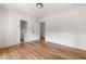 Open bedroom featuring hardwood floors, white walls, and trim, leading to an ensuite bathroom at 1155 Peachtree Battle Nw Ave, Atlanta, GA 30327